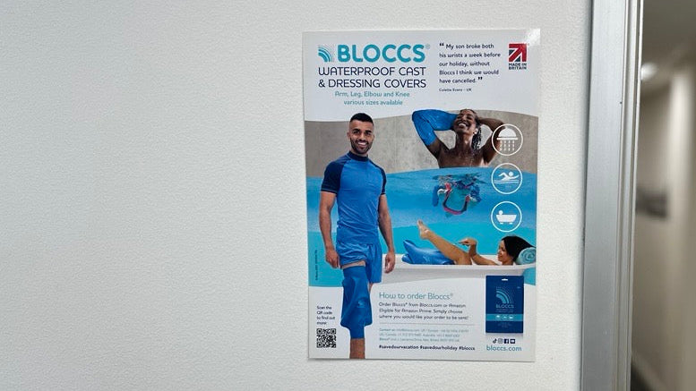 Advertisement for BLOCCS waterproof cast and dressing covers on a wall.